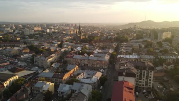 Flyg mot en fantastisk stad vid soluppgången. Morgon i den lilla staden Lviv i Ukraina. Solarna strålar vid horisonten faller på husen. Varma ljusstrålar i morgonstaden. — Stockvideo