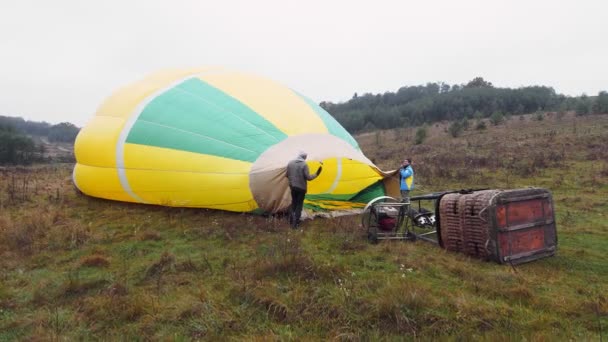 Gezginler balonu sıcak havayla şişirir ve bulutların üzerinde bir balonla uçmaya hazırlanırlar. Balon uçuşu için hazırlanıyor. — Stok video