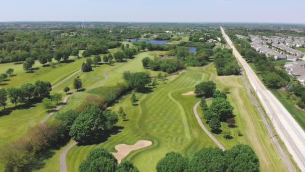Vista aérea a partir do topo n do campo de golfe. Pessoas e carros em um campo de golfe de uma altura. — Vídeo de Stock