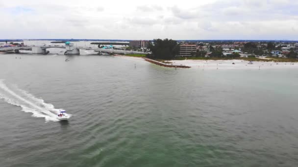 Luchtfoto motorboot die snel vaart op de zee in de buurt van de kust. Bewolkte dag en zee kustlijn met drone — Stockvideo
