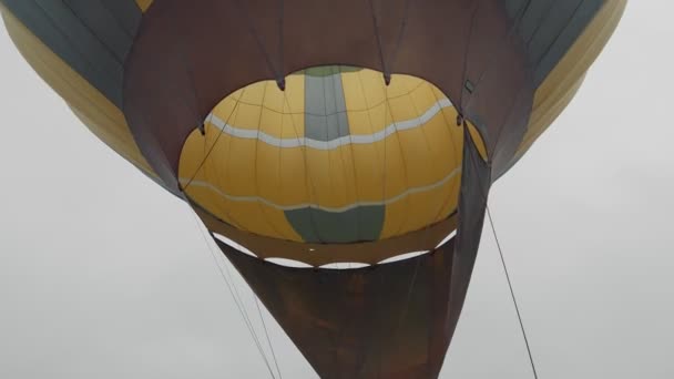 Путешественники накачивают воздушный шар теплым воздухом и готовятся к полету на воздушном шаре над облаками. Подготовка к полету на воздушном шаре — стоковое видео