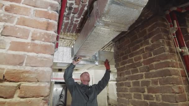 O mestre executa medições de canais de ventilação na construção. O funcionário mede a abertura da ventilação com um medidor. — Vídeo de Stock