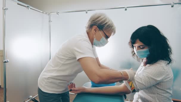 Bir laboratuvar çalışanı virüse karşı antikorlar için kan örneği alır. Hemşire kan akıtmaya hazırlanıyor. Hasta kan bağışlıyor.
