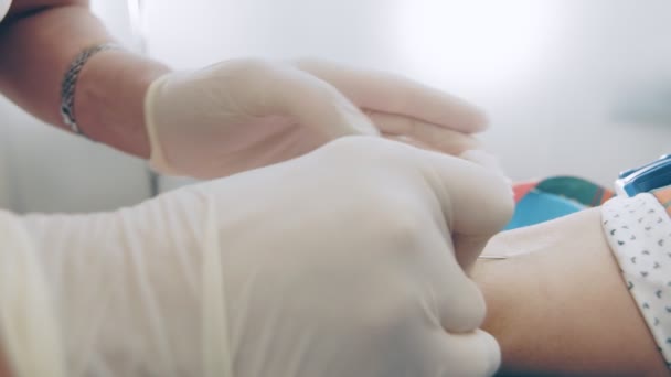 Pielęgniarka przekłuwa dłoń igłą. Pracownik laboratorium pobiera próbkę krwi na obecność przeciwciał przeciwko wirusowi. Pobieranie próbek krwi w laboratorium — Wideo stockowe