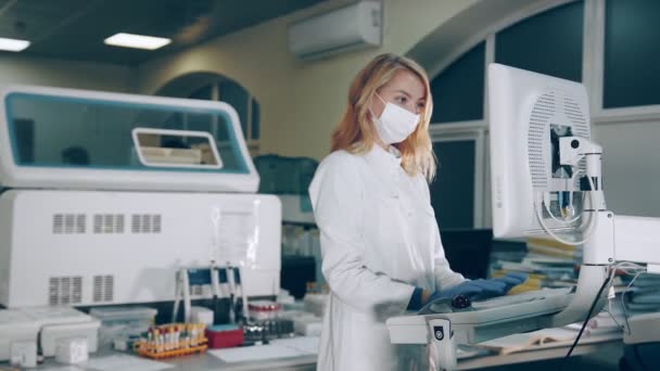 Mikrobiologe forscht im Labor. Der Forscher führt einen biochemischen Analysetest durch. Eine Labormitarbeiterin arbeitet mit einem biochemischen Analysegerät. — Stockvideo