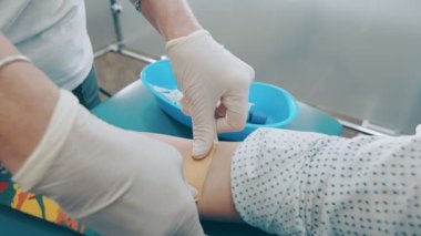 Bir laboratuvar çalışanının hastaların koluna yara bandı yapıştırması. Laboratuvardaki kan örnekleri tamamlandı..