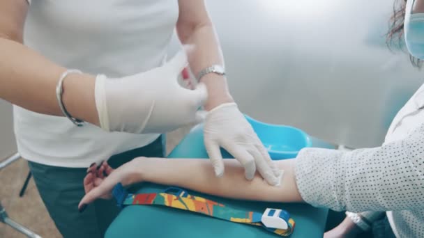 Pracownik laboratorium miesza próbki krwi. Asystent laboratoryjny trzyma probówkę ze świeżo pobraną krwią i miesza ją.. — Wideo stockowe