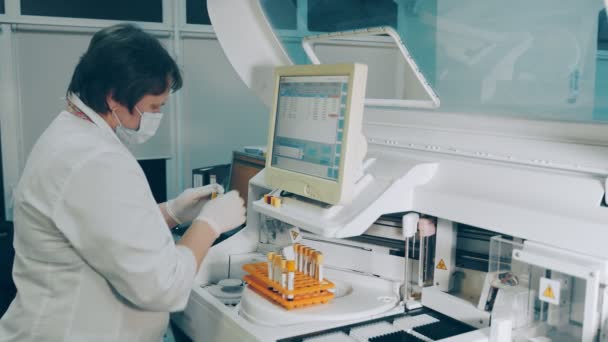 微生物学家在实验室进行研究.研究人员进行了生化分析测试。一名女性实验室工作人员使用生化分析仪器. — 图库视频影像