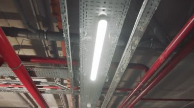 Odanın tavanında iletişim var. Teknik odanın tavanında egzoz boruları, gaz boruları ve kablo ağları var. Binanın tavanında hareket ve dağ manzarası.