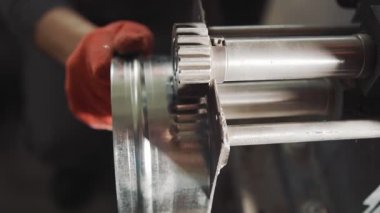 Profesyonel bir mühendis metal levha ile çalışır. Usta havalandırma kanalları oluşturmak için metal bir levhaya kesik atıyor..