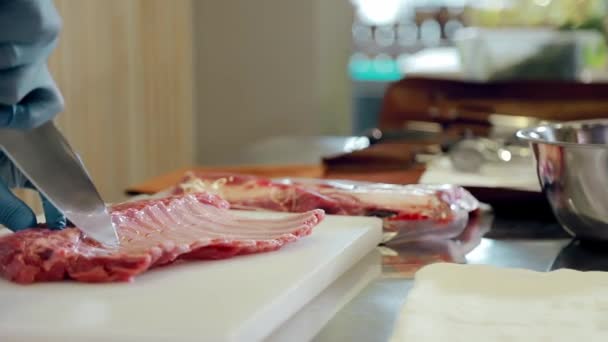 Lammfleisch in Scheiben schneiden. Der Metzger verarbeitet ein Stück Lamm. Metzger schneidet mit Messer Schnitzel aus Lammrippen — Stockvideo