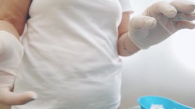 Tıbbi analiz için kan örneği alıyorum. Bir laboratuvar çalışanı elinde bir kan örneği tutuyor ve onu sallıyor. Böylece tüpteki kan pıhtılaşma önleyici ile tamamen karışıyor.