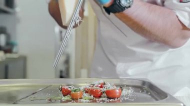 Şef vişneli domates salatası hazırlıyor. Pişirme çeşnili domates..