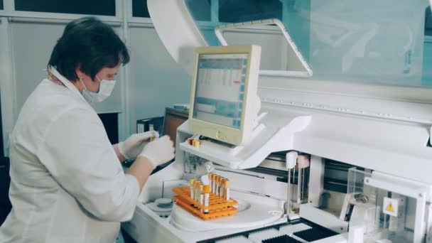 미생물학자들은 실험실에서 연구를 사회 한다. 연구원은 생화학적 분석 테스트를 실시 한다. 한 여성 실험실 근로자가 생화학 분석 장치를 가지고 일하고 있다. — 비디오