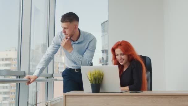 Los trabajadores de oficina generan ideas en la oficina y trabajan con una computadora portátil. Emociones felices conduce el flujo de trabajo. Hombre y mujer de nacionalidad caucásica. — Vídeos de Stock