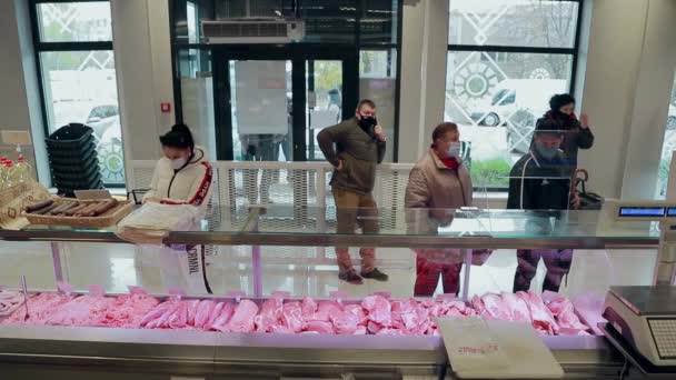 UKRAINE. LVIV. 05 . 12 . 2020 입니다. 정육점에서 쇼핑하는 사람들 이요. 손님이 식품점의 진열창에서 제품을 검사 한다. — 비디오