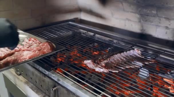 Chef kookt grote stukken vers lam op de grill. Vlees koken op de grill. De chef spreidt stukjes lamsvlees uit op de grill — Stockvideo