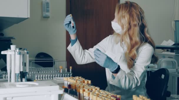 Blood test in the laboratory. The lab technician examines the blood tubes and checks the barcode and serial number of the biochemical tests in the laboratory. Developers of potential medicines and — Stock Video