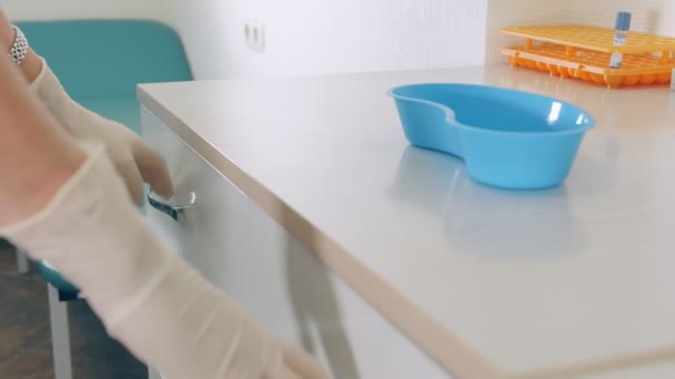 Storage of blood test tubes. The lab technician opens the drawer for storing test tubes and takes out various medical devices and test tubes. — Stock Video