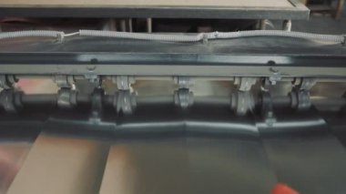 Metal bir plakayı kesen bir makine. Metal işleme devam ediyor. Havalandırma kutularının oluşturulması.
