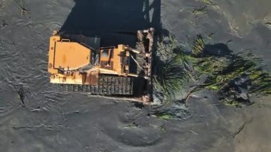 En üstteki hava manzarası. Büyük buldozer, gölün dibini çalılıklar ve bataklıklardan temizliyor. Gölün dibini yeşil alglerden temizliyorum. Ağır ekipman işi.