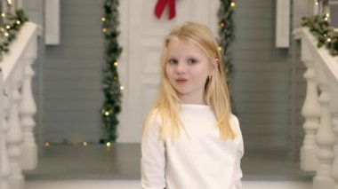 Kafkas uyruklu genç bir kızın portresi elleriyle gözlerini kapatıyor ve kameraya bakarak gözlerini açıyor. Mavi gözlü ve sarı saçlı kız kameraya yakından bakıyor..