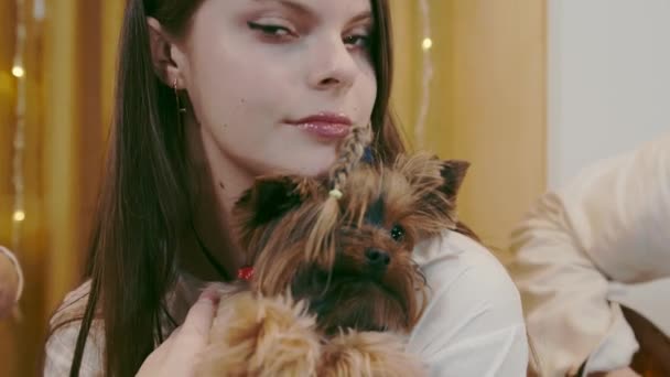 Ragazza che tiene tra le braccia, il suo animale domestico, un cane razza yorkshire terrier. — Video Stock