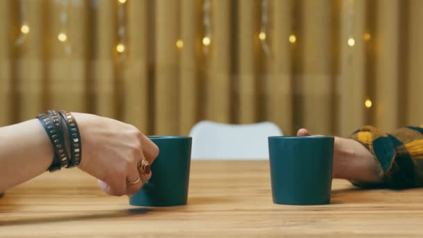 Koffie pauze. Vrouw en man nemen groene kopjes met koffie of thee en tillen ze op. Twee mensen drinken koffie van dichtbij. — Stockvideo