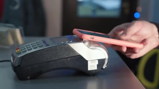 Pagamento tramite smartphone. Una mano maschile paga utilizzando il sistema NFC in un telefono cellulare. Pagamenti senza contatto. — Video Stock
