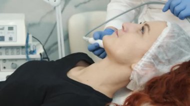 Kaplıcada yatan ve cildini yenilemek ve tazelemek için ameliyat olan mutlu bir kadın. Bir kozmetoloji kliniğinde yüz gençleştirme prosedürleri.