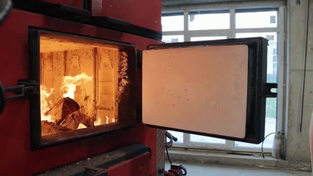 Boiler room on environmentally friendly fuel .stoker boiler room worker who throws wooden bars into the boiler. firewood burns in furnace, burning process, house heating, winter season — Stock Footage Boiler room on environmentally friendly fuel .stoker boiler room worker who throws wooden bars into the boiler. firewood burns in furnace, burning process, house heating, winter season Video Clip