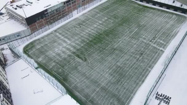 Rengøring af fodboldbanen fra sne. Sne falder på en fodboldbane. En maskine, der renser sneen på en fodboldbane. Forberedelse af fodboldbanen til kampen om vinteren – Stock-video