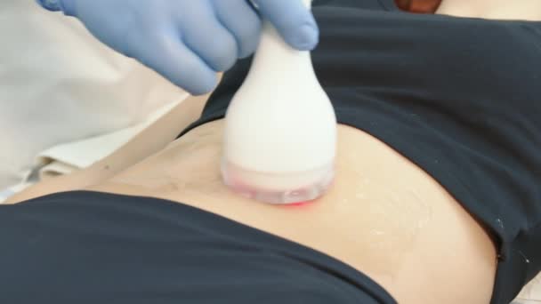 O médico realiza procedimentos cosméticos usando um dispositivo inovador para regeneração da pele e massagem corporal. — Vídeo de Stock