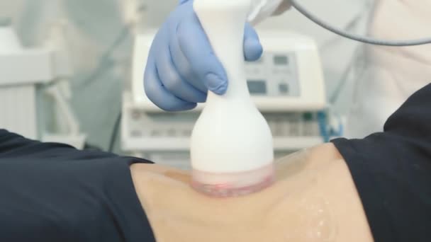 O médico realiza procedimentos cosméticos usando um dispositivo inovador para regeneração da pele e massagem corporal. — Vídeo de Stock