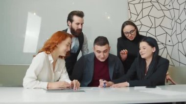 Şirketin kadın başkanı çalışana şirketin başarısından ve büyümesinden bahseder. İş kadını, şirketlerin prodüksiyon bilgi grafiklerini gösteriyor. Ofis çalışanları bir toplantıda..