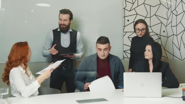 Ofisteki neşeli şirket çalışanları mutlu bir şekilde gülümsüyor ve gelecek için planlarını tartışıyorlar. Bir grup başarılı insan olumlu bir toplantı düzenliyor.. — Stok video