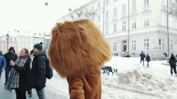 Ucrânia Lviv 10.02.2021 Um homem disfarçado de leão caminha pela rua no inverno entre o povo. Entretenimento de rua do primogênito. Leão diverte as pessoas — Vídeo de Stock