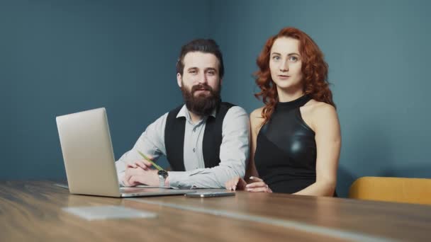 Férfi és nő együtt dolgoznak az irodában. Boldog emberek mosolyognak a munkában és az irodában. Szakállas, kaukázusi nemzetiségű férfi és nő. — Stock videók