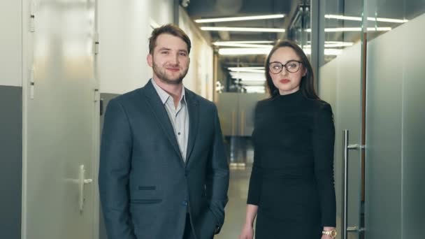 Portrait de deux hommes et femmes d'affaires debout dans le centre d'affaires et regardant la caméra. partenaires d'affaires après la réunion. — Video