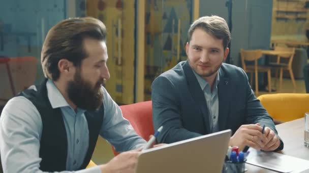 Két férfi üzlettárs, párbeszédet folytatnak és kommunikálnak az irodában. A vállalatok belső stratégiájának megvitatása az ülés során. — Stock videók