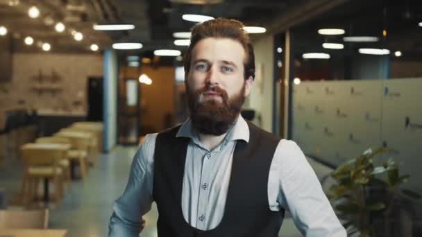 Close up retrato de um empresário de sucesso com uma barba de aparência caucasiana. O homem dobra os braços e olha atentamente para a câmera. O olhar de um líder de negócios confiante. — Vídeo de Stock