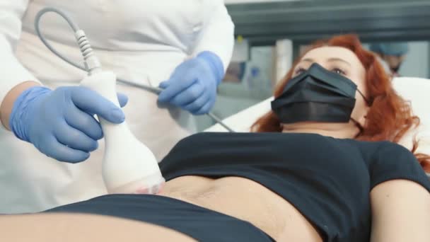 Läkaren utför kosmetiska procedurer med hjälp av en innovativ anordning för hudregenerering och kroppsmassage. — Stockvideo