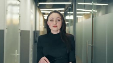 Çekici bir genç kadının portresi kameraya bakarak baştan çıkarıcı bir şekilde gözlüklerini çıkarıyor. Avrupa görünümlü, kendine güvenen bir iş kadını.