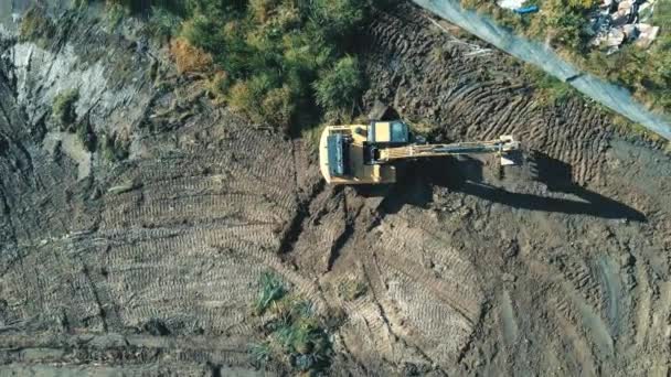 Vista aerea sul lavoro superiore di un escavatore che cancella e livella l'area. L'escavatore esegue lavori geodetici. Livellamento del fondo del futuro lago — Video Stock