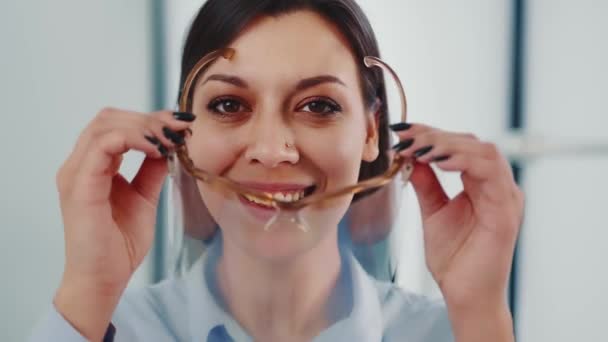 Zbliżenie twarzy dentystki w prywatnej klinice. Portret dentystki w masce ochronnej na twarzy i uśmiechu. — Wideo stockowe