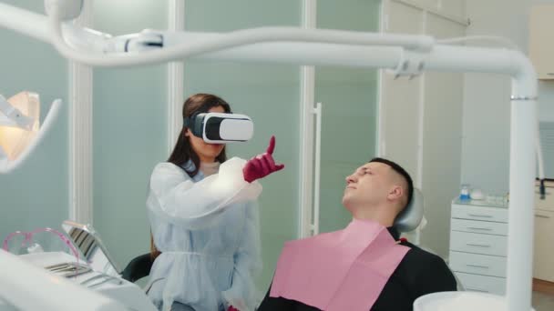 Dentista feminina a olhar para os óculos de pressão arterial raio-X da paciente. Odontologia moderna. Odontologia com realidade virtual. — Vídeo de Stock