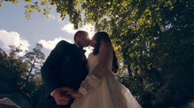 Güneşli bir parkta birbirine aşık bir çift. Güneş ışınları aydınlatıcı resmin arkasındaki kameraya yansıyor..