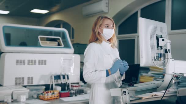 Onderzoeker van microbiologie, werkzaam in het laboratorium drukt op de toetsen van het touchscreen van het apparaat van biochemische analyse van bloed op antilichamen tegen coronavirus covid 19. Werk in het laboratorium. — Stockvideo