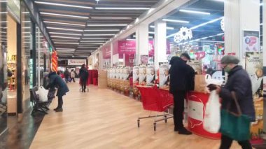 Ukrayna Lviv 10.03.2021 kişi süpermarketteki kasada. Büyük bir alışveriş merkezinin salonu ve naylon poşetlere mal dolduran insanlar..