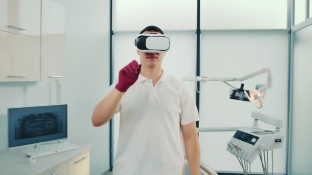 Porträtt av en tandläkare som använder augmented reality glasögon inom tandvården. Framtidens tandvård. — Stockvideo